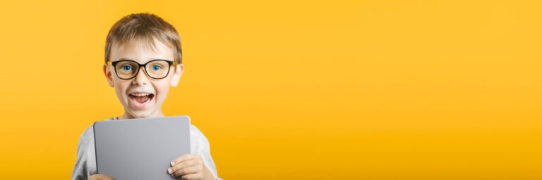 Happy child boy  holding a tablet ipade for your information on the blue background