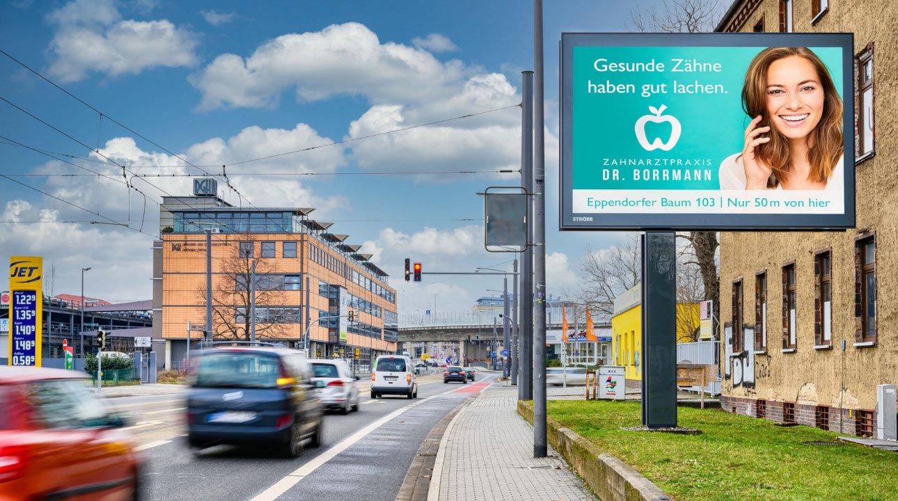 Eine lächelnde Frau auf einem Zahnarzt-Werbeplakat neben einer befahrenen Straße.